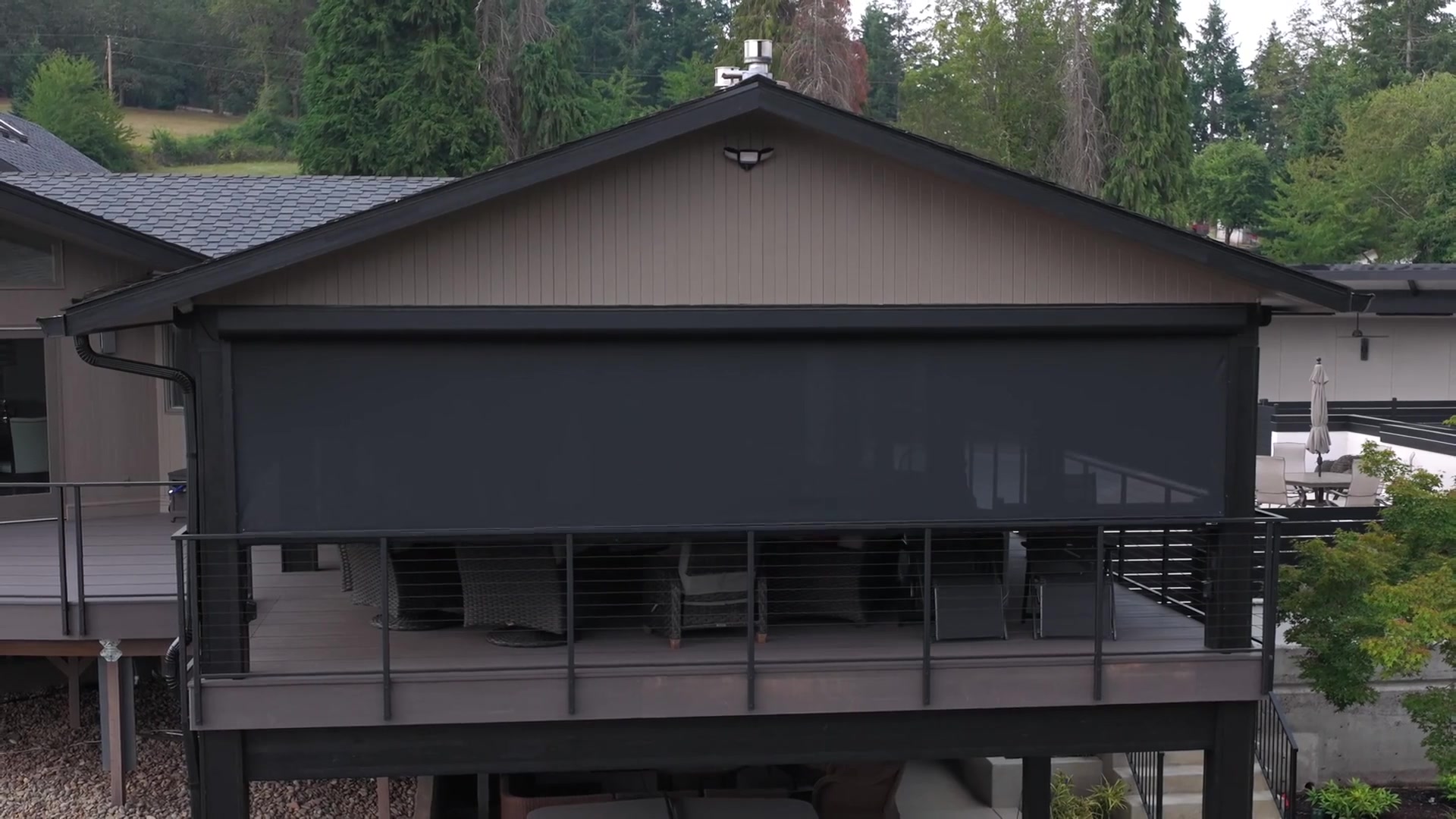 Fenetex motorized screens fully deployed on covered deck, protecting outdoor living space