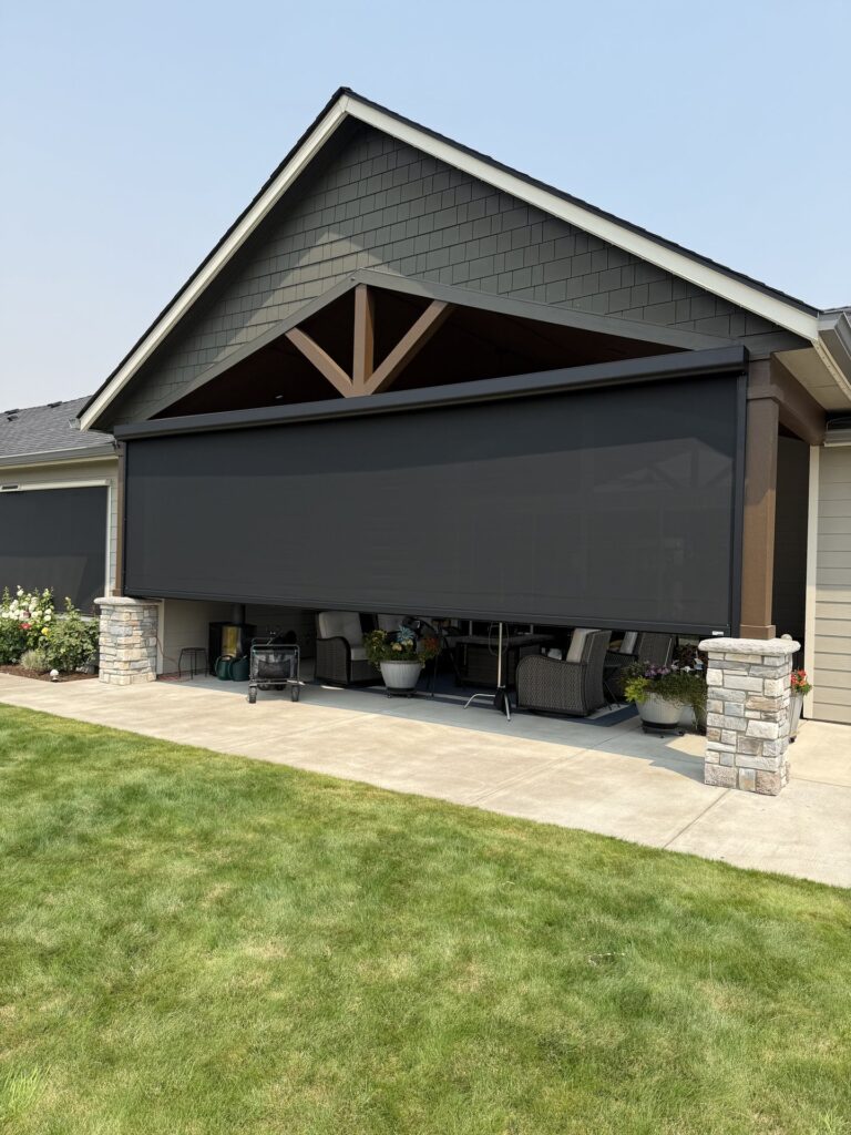 Motorized shade screen fully lowered across a gabled covered patio in Lebanon, Oregon